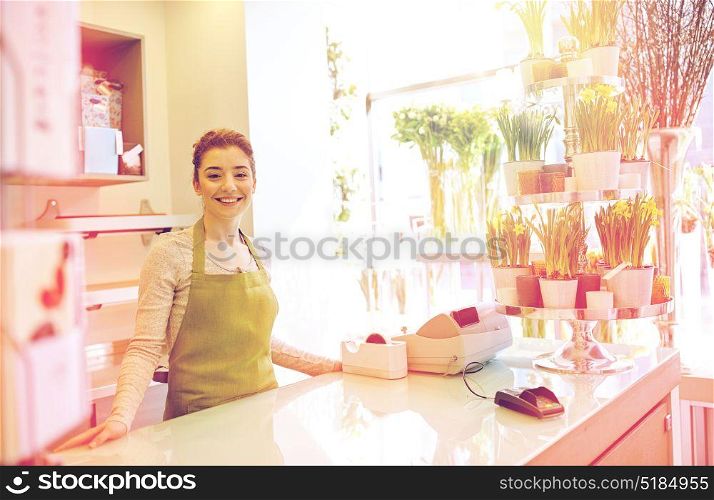 people, business, sale and floristry and concept - happy smiling florist woman at flower shop counter. happy smiling florist woman at flower shop counter