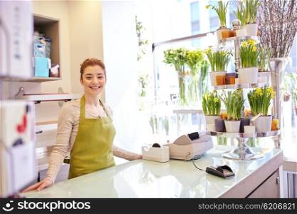 people, business, sale and floristry and concept - happy smiling florist woman at flower shop counter