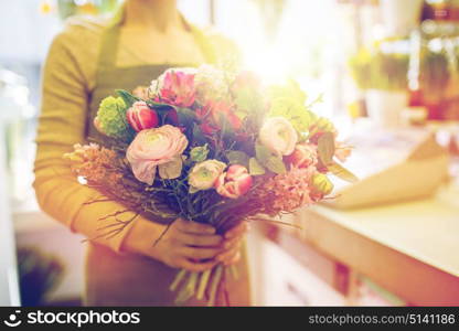 people, business, sale and floristry concept - close up of florist woman holding bunch at flower shop. close up of woman holding bunch at flower shop