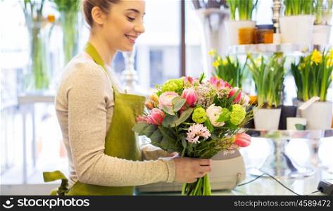 people, business, sale and floristry concept - close up of happy florist woman making bunch at flower shop
