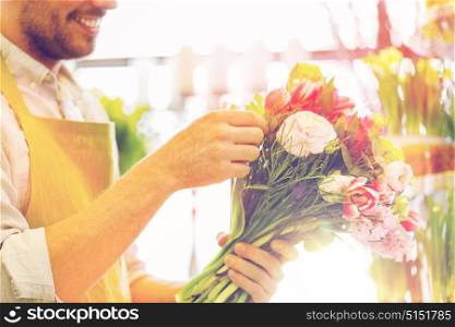 people, business, sale and floristry concept - close up of happy smiling florist man making bunch at flower shop. close up of florist man with bunch at flower shop