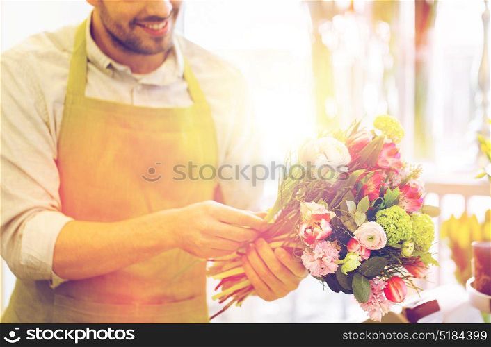 people, business, sale and floristry concept - close up of happy smiling florist man making bunch at flower shop. close up of florist man with bunch at flower shop