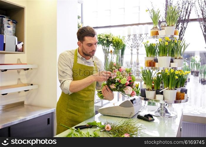 people, business, sale and floristry concept - florist man making bunch at flower shop