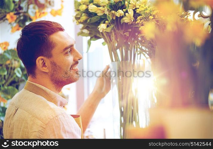 people, business, sale and floristry concept - happy smiling florist man at flower shop. happy smiling florist man at flower shop