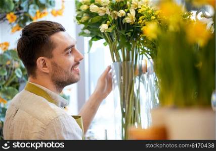 people, business, sale and floristry concept - happy smiling florist man at flower shop