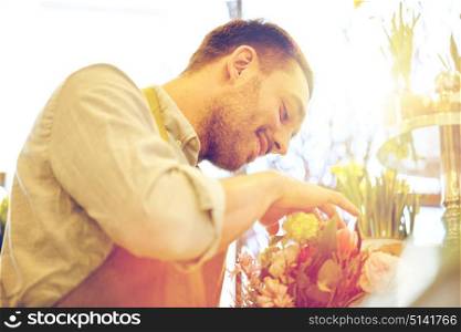 people, business, sale and floristry concept - happy smiling florist man making bunch at flower shop. smiling florist man making bunch at flower shop