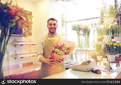 people, business, sale and floristry concept - happy smiling florist man with bunch at flower shop. smiling florist man making bunch at flower shop