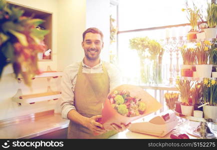 people, business, sale and floristry concept - happy smiling florist man with bunch at flower shop. smiling florist man making bunch at flower shop