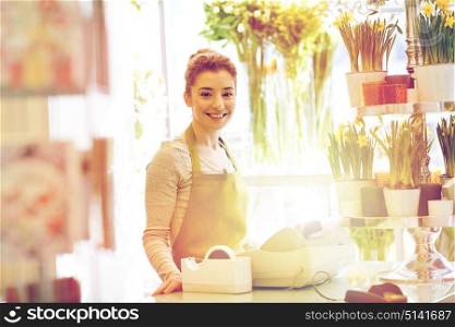 people, business, sale and floristry concept - happy smiling florist woman at flower shop cashbox. smiling florist woman at flower shop cashbox