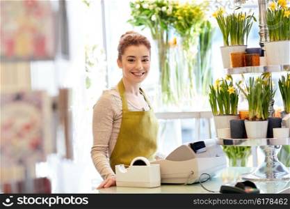 people, business, sale and floristry concept - happy smiling florist woman at flower shop cashbox