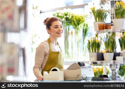 people, business, sale and floristry concept - happy smiling florist woman at flower shop cashbox
