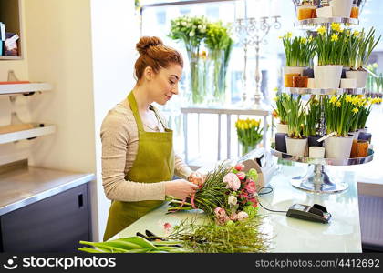 people, business, sale and floristry concept - happy smiling florist woman making bunch at flower shop