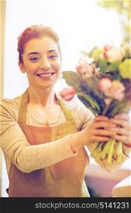 people, business, sale and floristry concept - happy smiling florist woman making bunch at flower shop. smiling florist woman making bunch at flower shop
