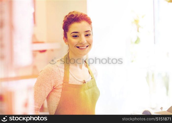people, business, sale, gardening and floristry concept - happy smiling florist woman or gardener at flower shop. smiling florist woman or gardener at flower shop
