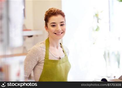people, business, sale, gardening and floristry concept - happy smiling florist woman or gardener at flower shop