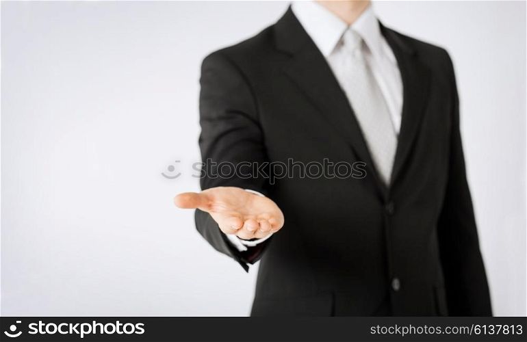 people, business, technology and advertisement concept - close up of man hand showing something on empty palm