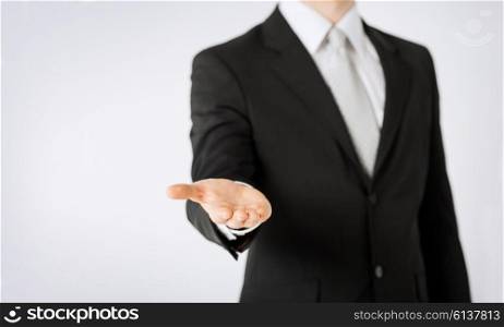 people, business, technology and advertisement concept - close up of man hand showing something on empty palm
