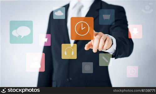people, business, technology and time management concept - close up of man pointing finger to clock icon projection