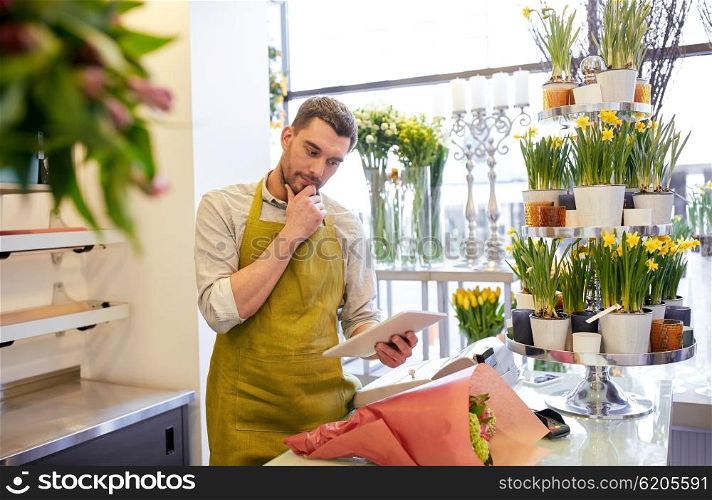 people, business, technology, sale and floristry and concept - florist man with tablet pc computer thinking at flower shop counter
