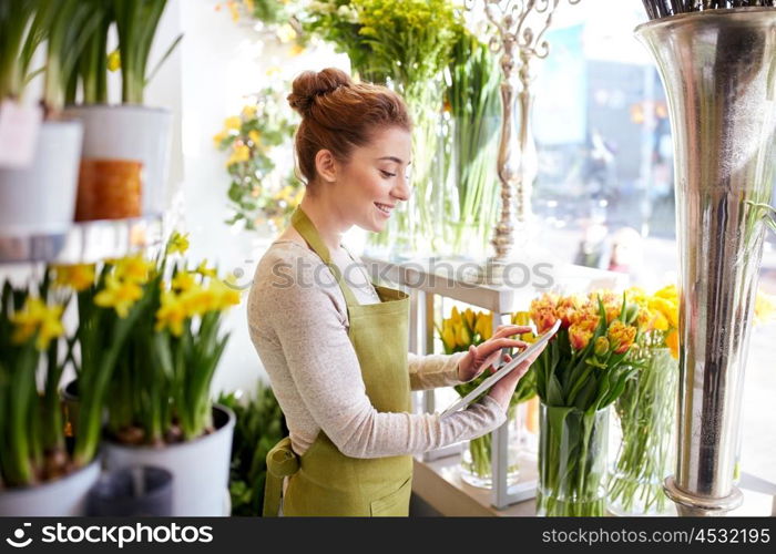 people, business, technology, sale and floristry and concept - happy smiling florist woman with tablet pc computer at flower shop