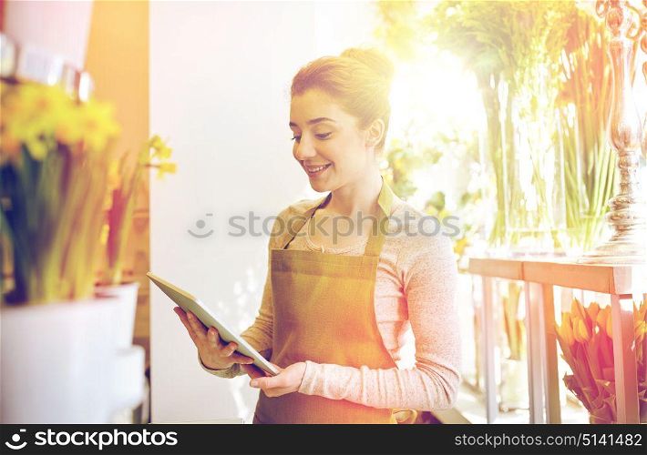 people, business, technology, sale and floristry and concept - happy smiling florist woman with tablet pc computer at flower shop. woman with tablet pc computer at flower shop