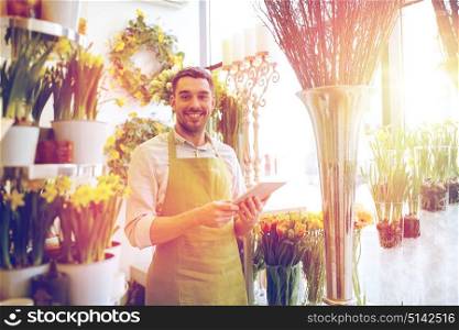 people, business, technology, sale and floristry and concept - happy smiling florist man with tablet pc computer at flower shop. man with tablet pc computer at flower shop