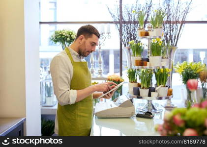 people, business, technology, sale and floristry and concept - happy smiling florist man with tablet pc computer at flower shop counter