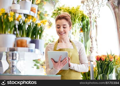 people, business, technology, sale and floristry and concept - happy smiling florist woman with tablet pc computer at flower shop