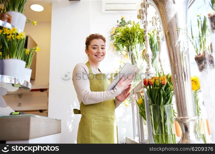 people, business, technology, sale and floristry and concept - happy smiling florist woman with tablet pc computer at flower shop