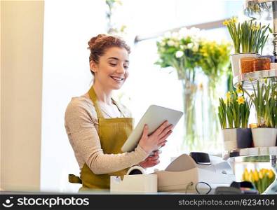 people, business, technology, sale and floristry and concept - happy smiling florist woman with tablet pc computer at flower shop