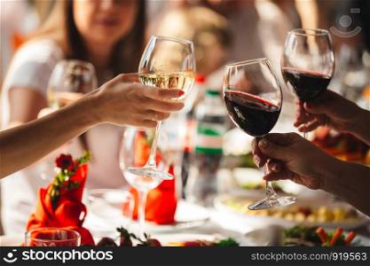 People celebrate and raise glasses of wine for toast. Group of man and woman cheering with sparkling champagne in rooftop restaurant. Cheers.. People celebrate and raise glasses of wine for toast. Group woman cheering with sparkling champagne in restaurant