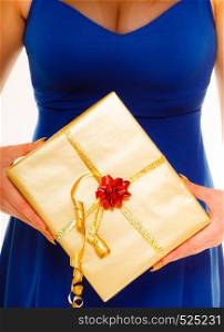 People celebrating holidays, love and happiness concept - girl blue dress with golden gift box isolated