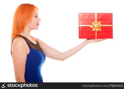 People celebrating holidays, love and happiness concept - red head girl holding big red gift box studio shot isolated. Time gifts