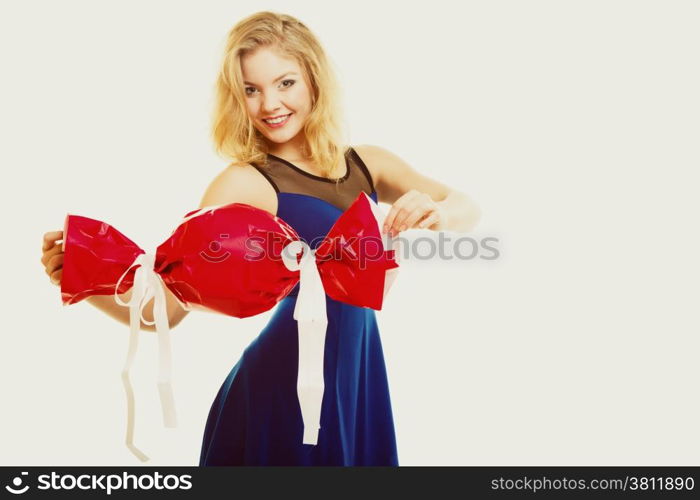 People celebrating holidays, love and happiness concept - smiling girl holding big red gift candy shaped studi shot on gray