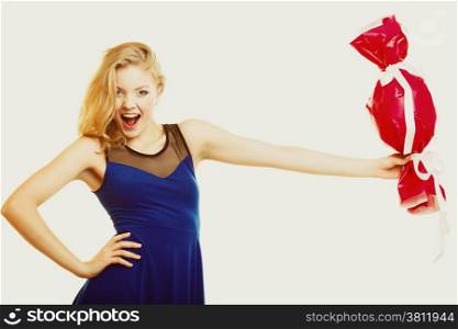 People celebrating holidays, love and happiness concept - smiling girl holding big red gift candy shaped studi shot on gray