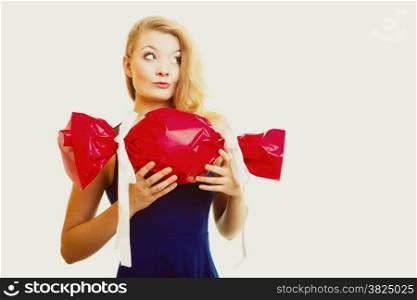 People celebrating holidays, love and happiness concept - smiling girl holding big red gift candy shaped studi shot on gray