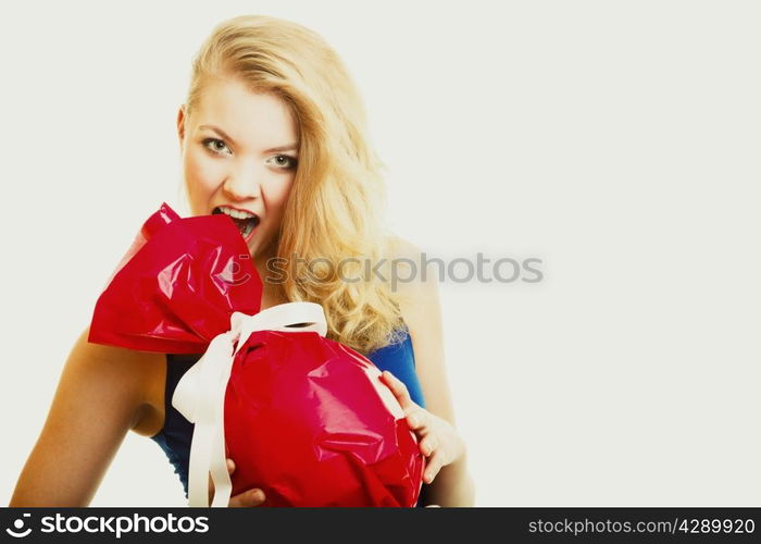 People celebrating holidays, love and happiness concept - smiling girl holding big red gift candy shaped studi shot on gray