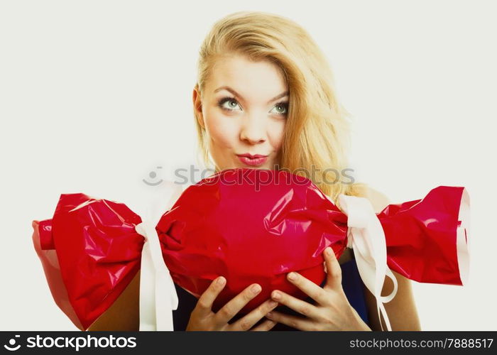 People celebrating holidays, love and happiness concept - smiling girl holding big red gift candy shaped studi shot on gray