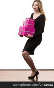 People celebrating xmas love and happiness concept. Funny blonde girl carrying presents stack of pink gift boxes, on white. Girl carrying many pink gift boxes