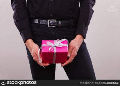 People celebrating xmas, love and happiness concept - young man holding present pink gift box in hands. man holding present pink gift box in hands