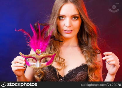 People celebration concept. Masquerade. Beautiful girl holding carnival mysterious mask on dark. Closeup woman face with carnival mask on dark