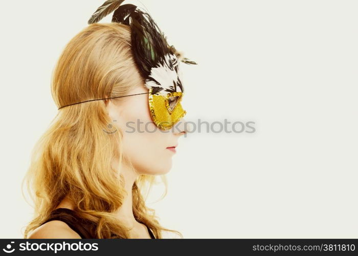 People celebration concept. Masquerade. Beautiful girl in carnival mysterious mask. Studio shot on gray