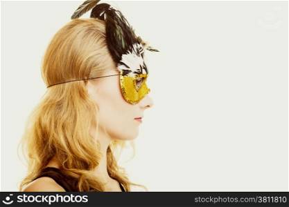 People celebration concept. Masquerade. Beautiful girl in carnival mysterious mask. Studio shot on gray