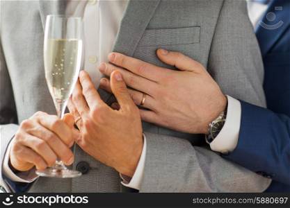 people, celebration, homosexuality, same-sex marriage and love concept - close up of happy married male gay couple in suits drinking sparkling wine from glass on wedding