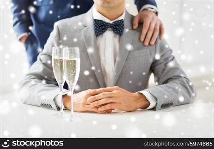 people, celebration, homosexuality, same-sex marriage and love concept - close up of married male gay couple in suits with sparkling wine glasses putting hand on shoulder on wedding over snow effect
