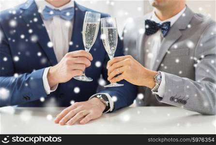 people, celebration, homosexuality, same-sex marriage and love concept - close up of happy married male gay couple in suits drinking sparkling wine and clinking glasses on wedding over snow effect