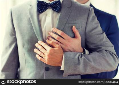 people, celebration, homosexuality, same-sex marriage and love concept - close up of happy male gay couple with wedding rings hugging