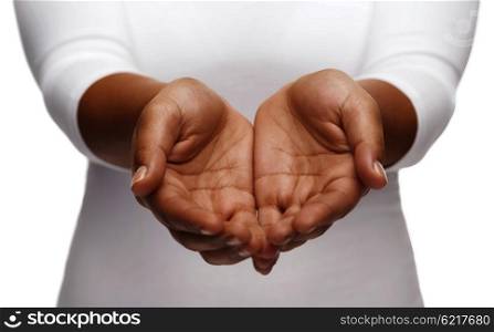 people, charity and poverty concept - close up of african american female empty cupped hands holding and showing something