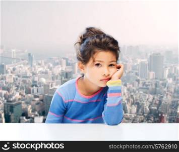 people, childhood and emotions concept - sad little girl over city background