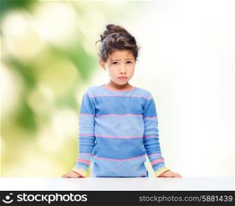 people, childhood and emotions concept - sad little girl over green background